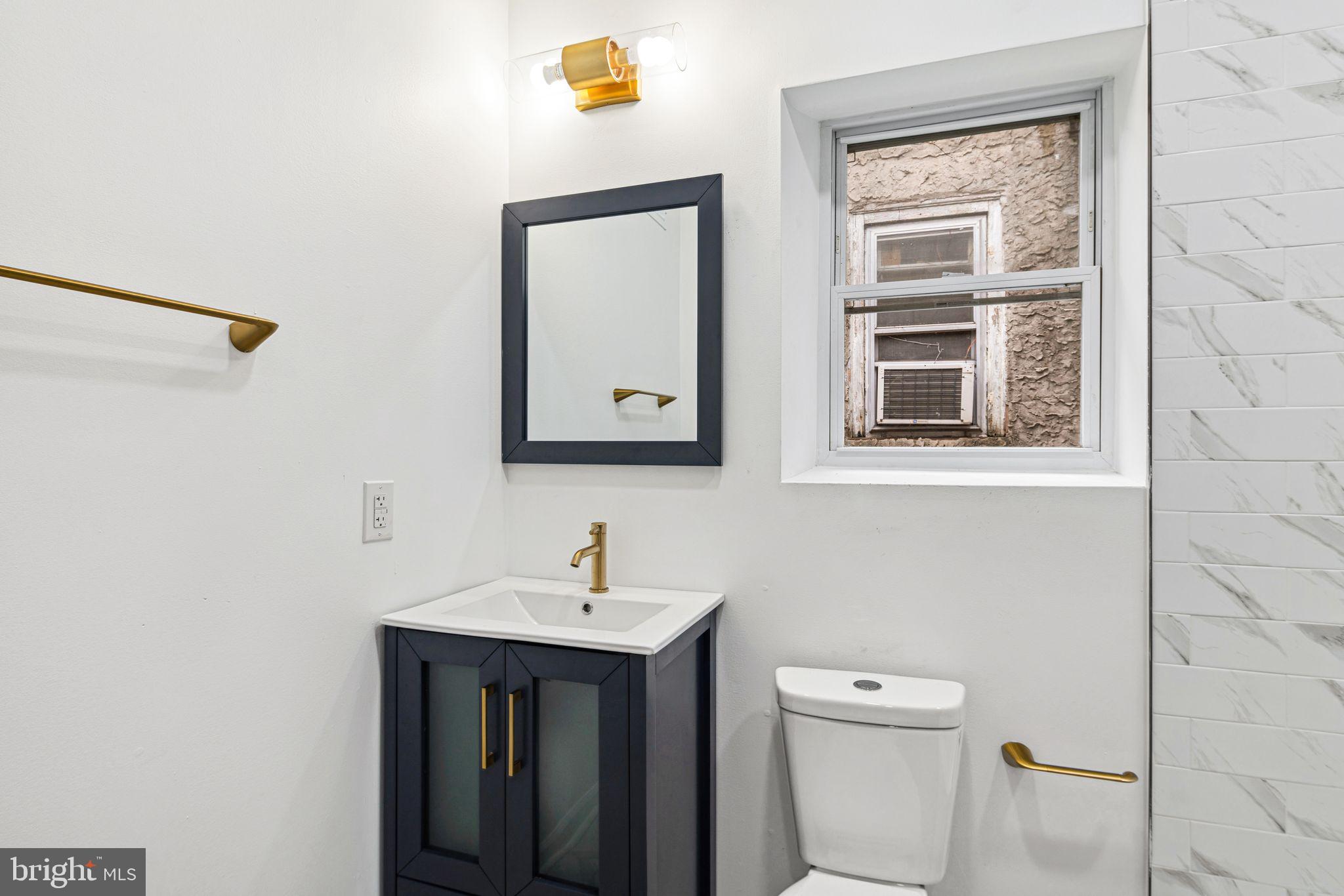 1319 North 28th Street Philadelphia, PA 19121 - Photo 7 of 9 a bathroom with a toilet a sink and mirror