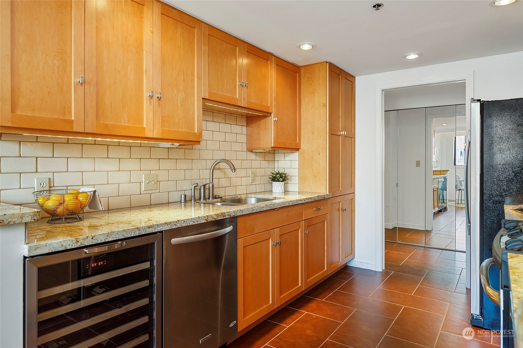 1120 Spring Street, Unit 401 Seattle, WA 98104 - Photo 14 of 34 a kitchen with stainless steel appliances granite countertop a sink and cabinets