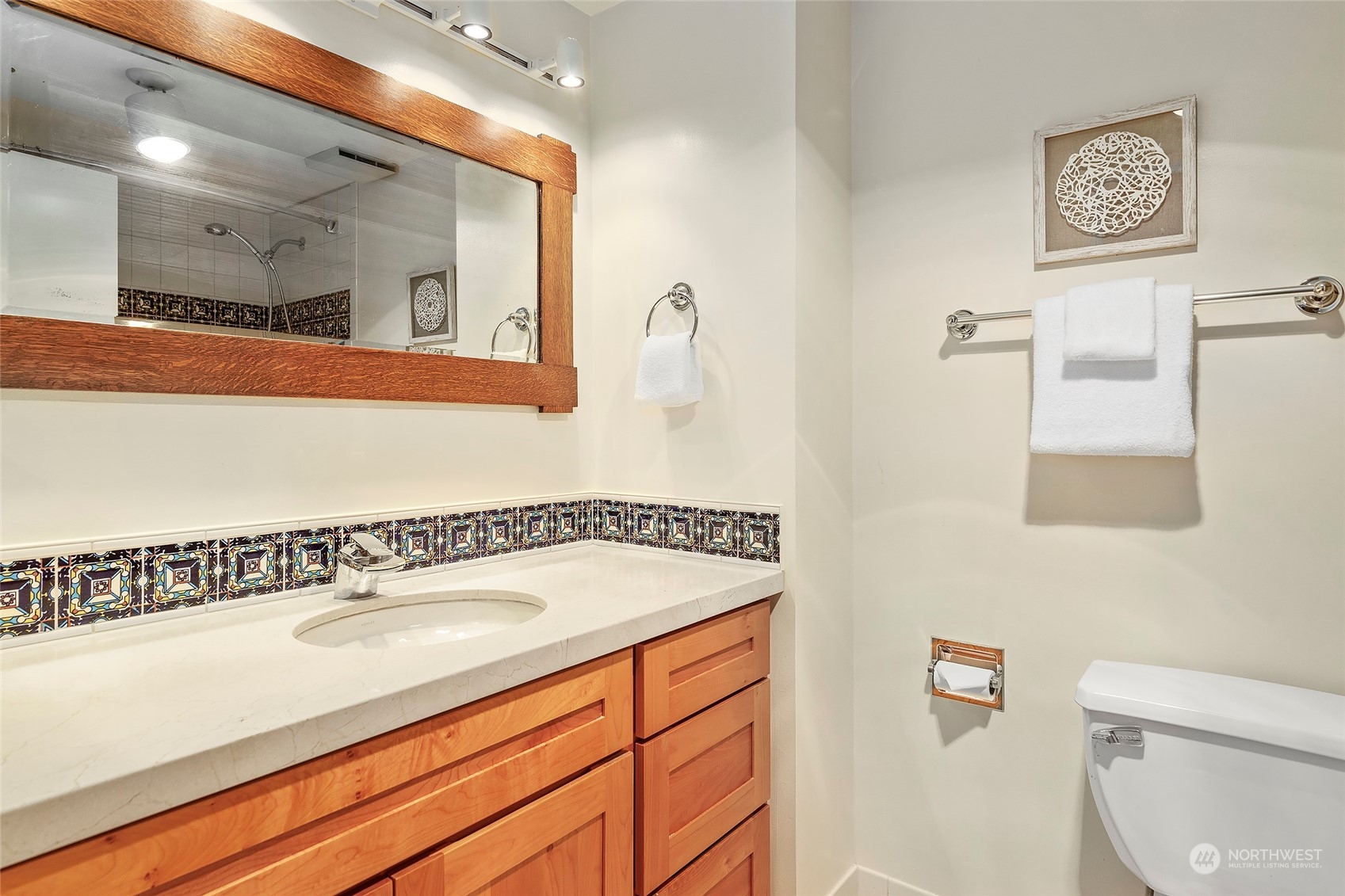 1120 Spring Street, Unit 401 Seattle, WA 98104 - Photo 19 of 34 a bathroom with a sink a toilet and a mirror