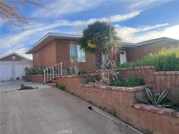 a front view of a house with a yard and potted plants