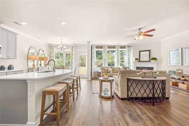 a kitchen with a refrigerator a stove a sink and white cabinets with wooden floor