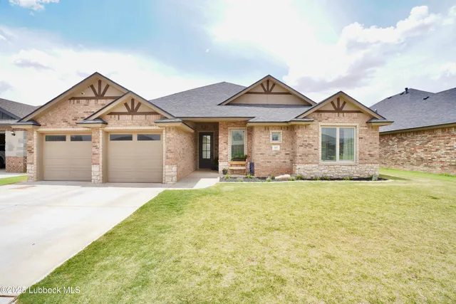 a front view of a house with a garden and yard