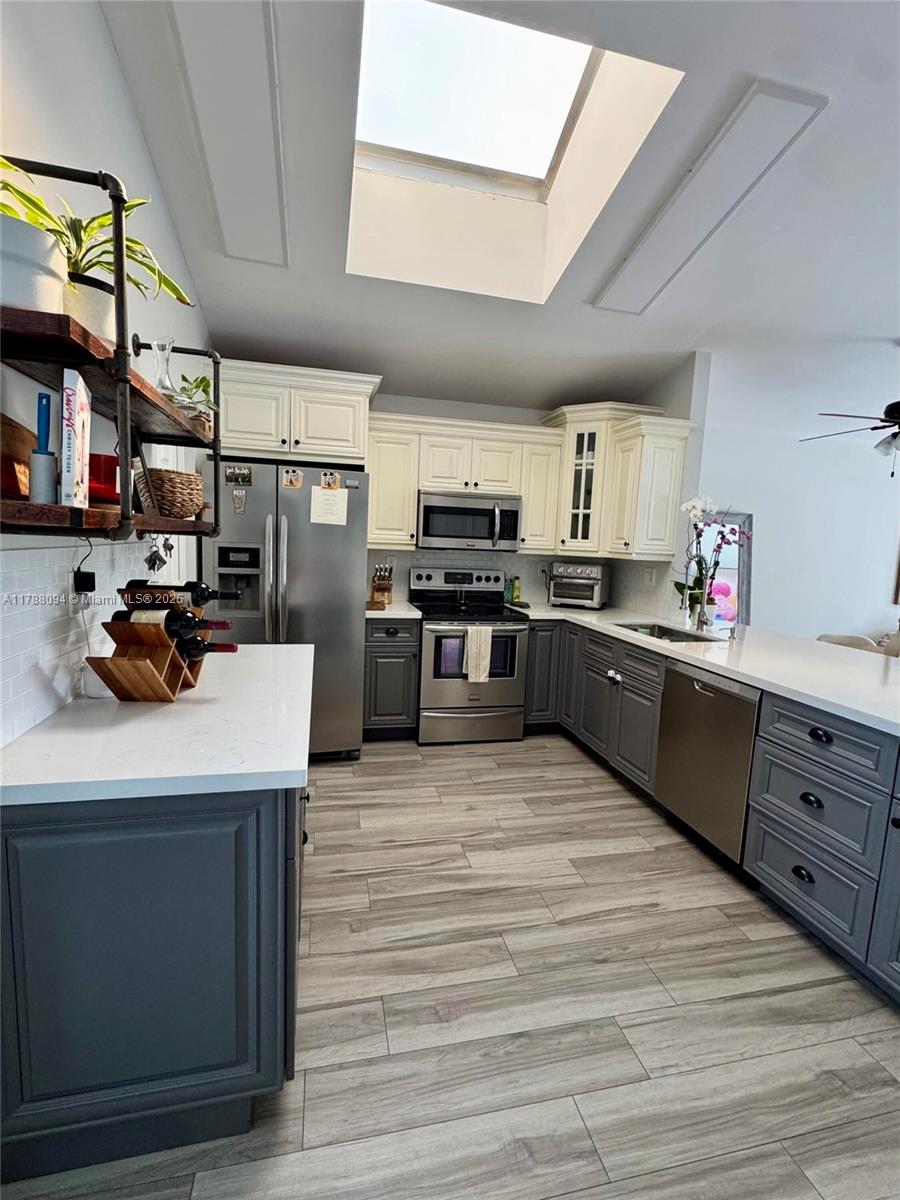 14626 Southwest 128th Court Road Miami, FL 33186 - Photo 15 of 41 a kitchen with stainless steel appliances kitchen island granite countertop a sink counter space cabinets and a sink