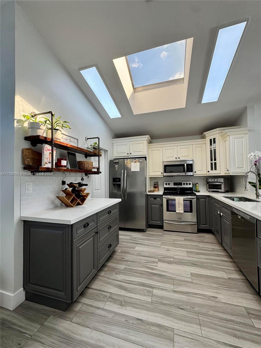 14626 Southwest 128th Court Road Miami, FL 33186 - Photo 18 of 41 a kitchen with stainless steel appliances kitchen island granite countertop a stove and a sink