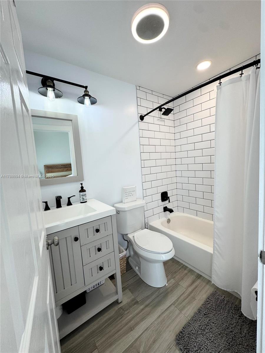 14626 Southwest 128th Court Road Miami, FL 33186 - Photo 30 of 41 a bathroom with a bathtub shower sink mirror vanity and toilet