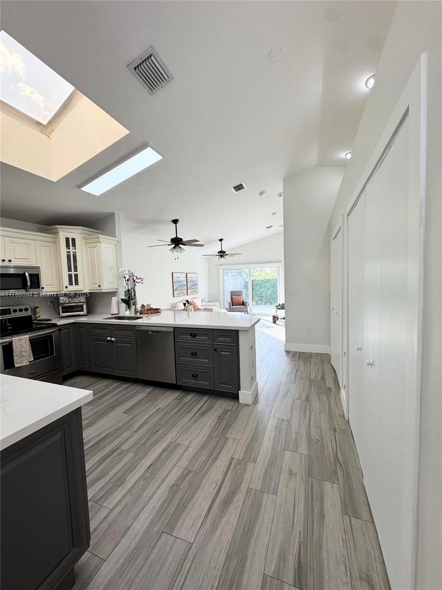 14626 Southwest 128th Court Road Miami, FL 33186 - Photo 5 of 41 a large white kitchen with wooden floors