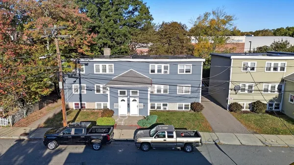 a view of a brick house with many windows and a table and chairs