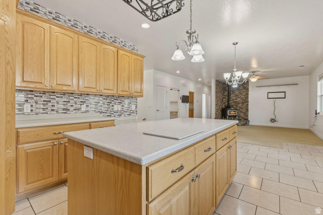 1001 Pine Valley Road Pine Valley, UT 84781 - Photo 21 of 49 Kitchen featuring a kitchen island, light wood finish cabinetry, light countertops, hanging lights, and a wood stove