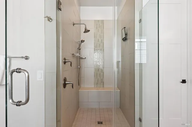 a bathroom with a double vanity sink toilet mirror and shower