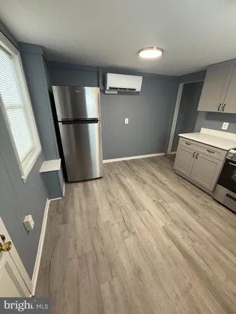 a view of empty room with wooden floor and electronic appliances