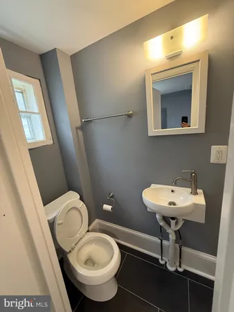 a bathroom with a toilet sink and mirror