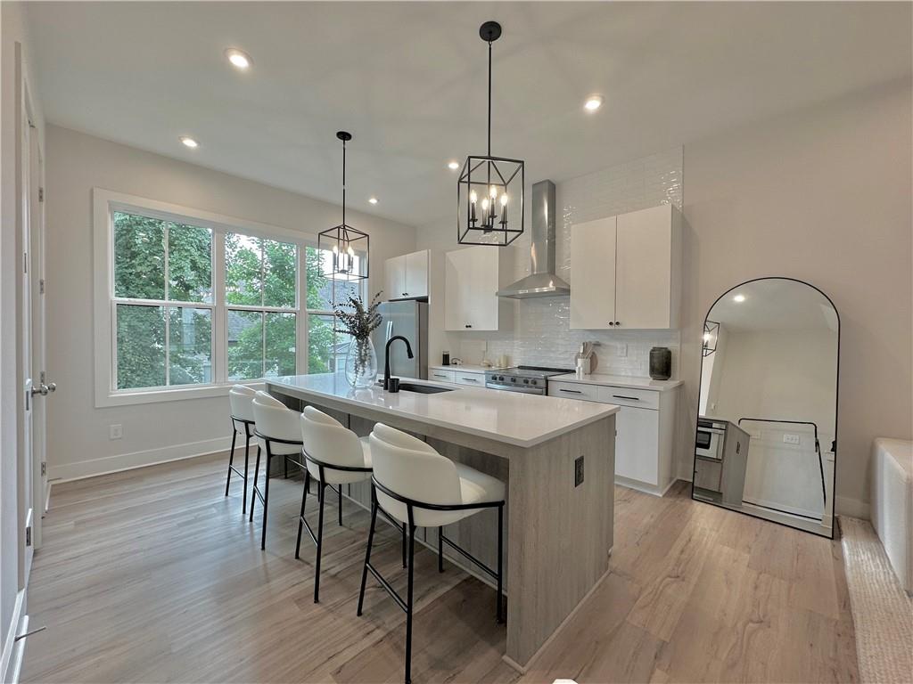 192 Chestnut Circle Atlanta, GA 30342 - Photo 2 of 16 a kitchen with stainless steel appliances granite countertop a stove a sink a refrigerator a dining table and chairs with wooden floor