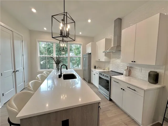 a large white kitchen with a large window