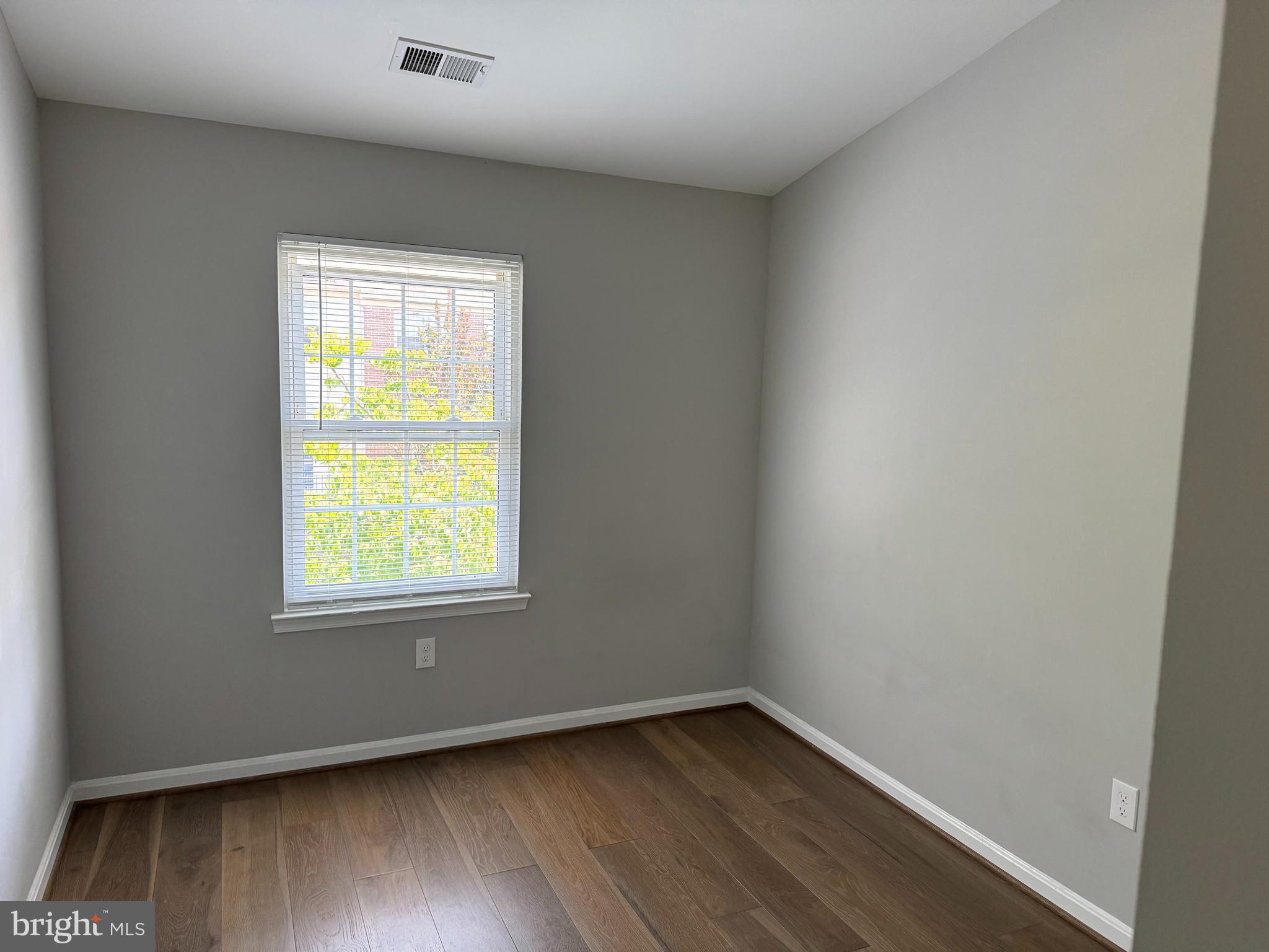 6110 George Baylor Drive Centreville, VA 20121 - Photo 8 of 12 an empty room with wooden floor and windows