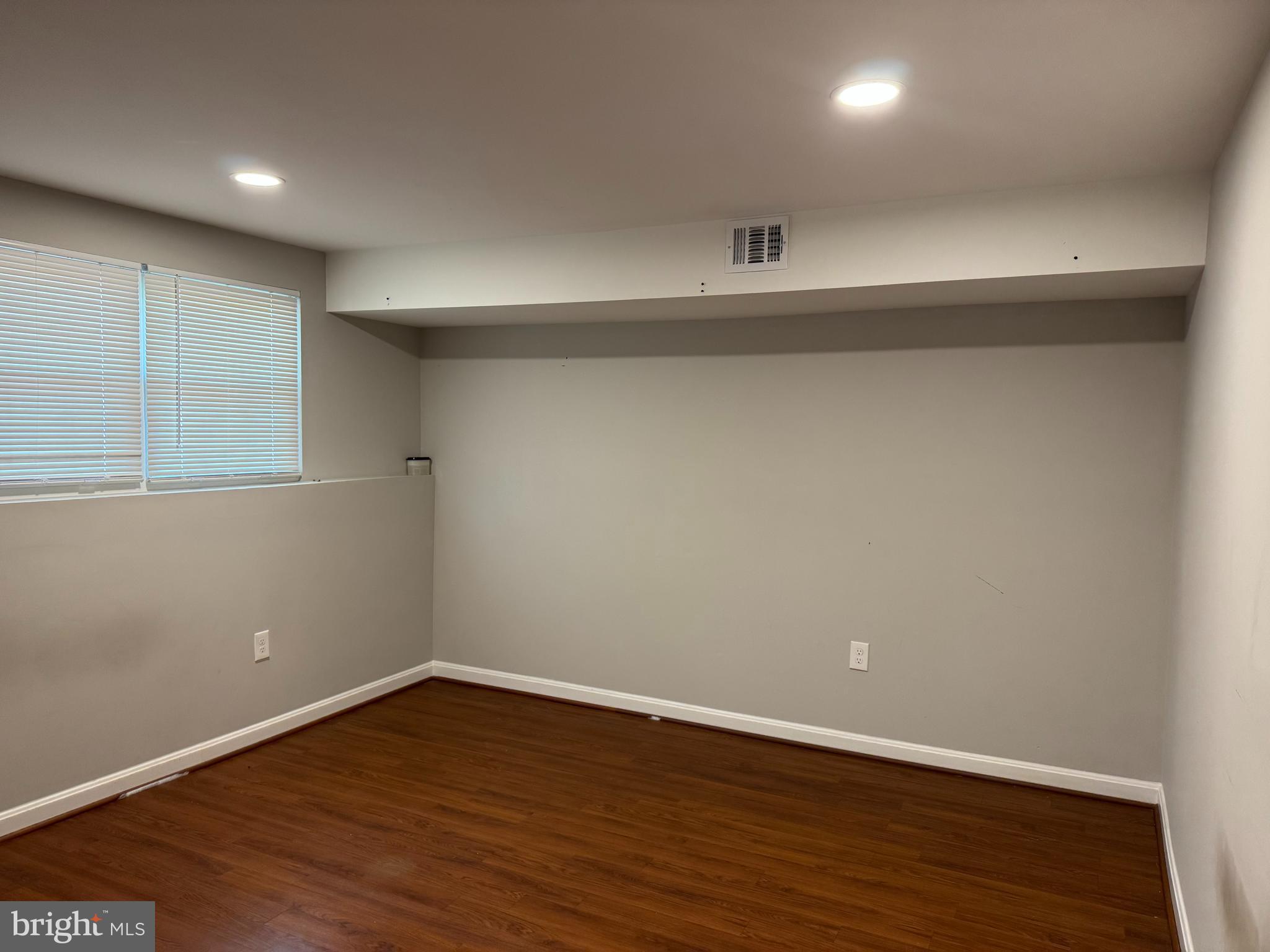 6110 George Baylor Drive Centreville, VA 20121 - Photo 9 of 12 a view of an empty room with wooden floor and a window