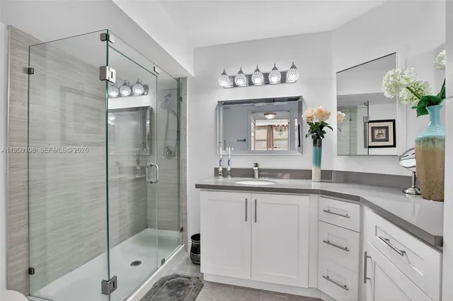 a bathroom with a shower sink and mirror