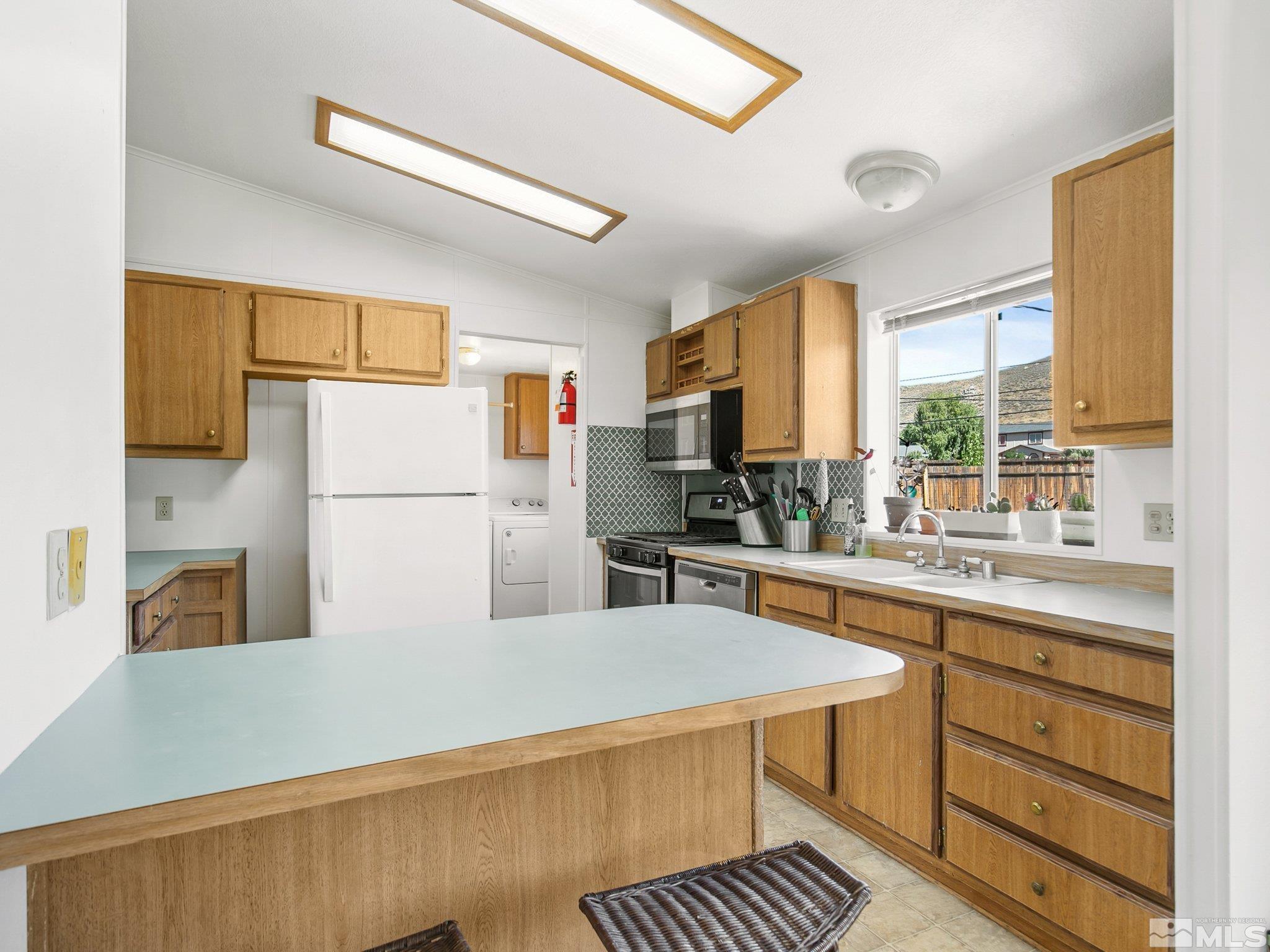 17280 Whippoorwill Lane Reno, NV 89508 - Photo 13 of 26 a kitchen with stainless steel appliances granite countertop a refrigerator sink stove and large window