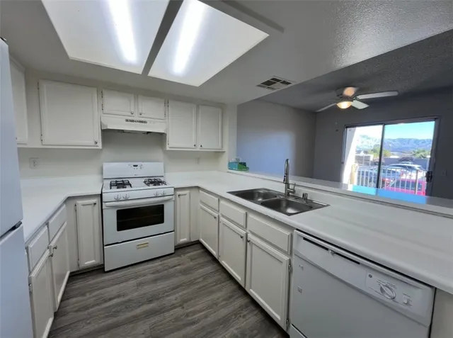 a kitchen with stainless steel appliances white cabinets and a stove top oven