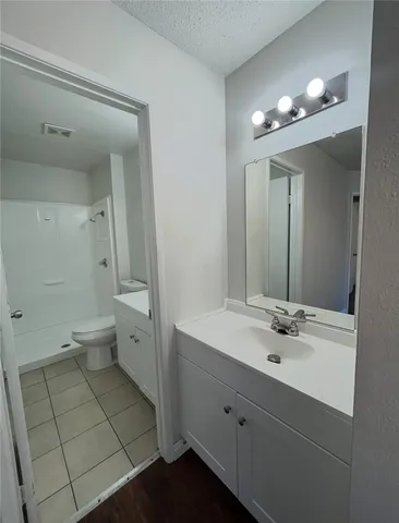 a spacious bathroom with a double vanity sink toilet and a mirror