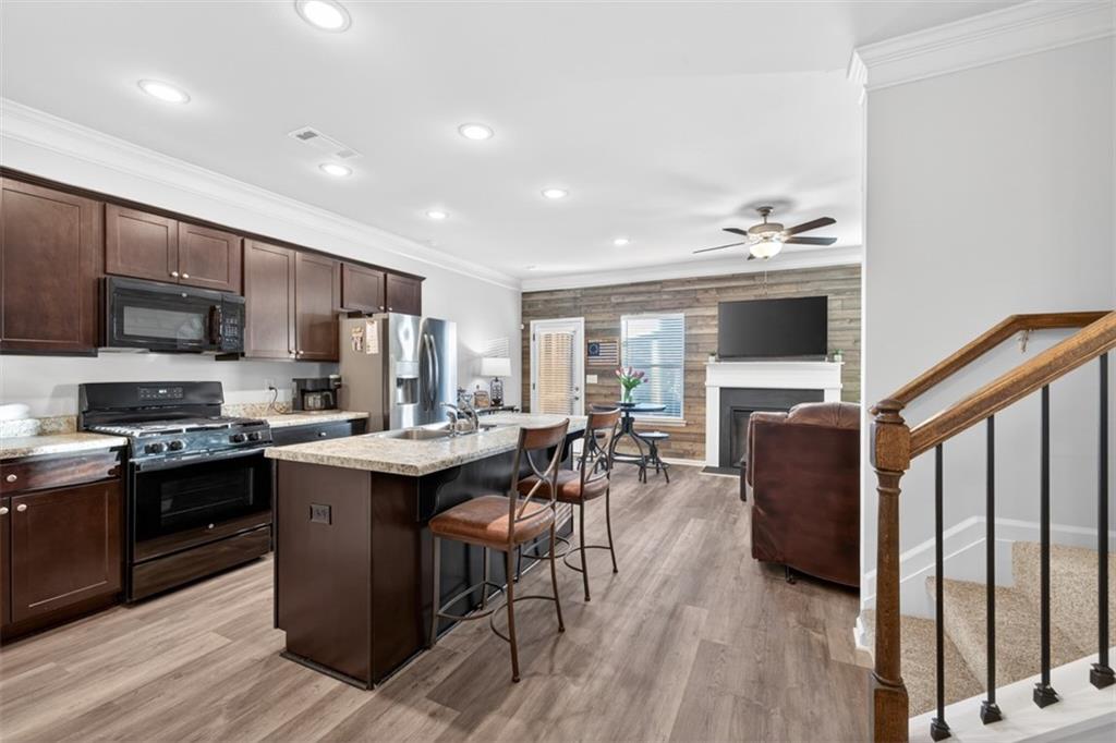 286 Turtle Creek Drive Winder, GA 30680 - Photo 5 of 39 a kitchen with stainless steel appliances granite countertop a stove top oven a sink dishwasher a dining table and chairs with wooden floor