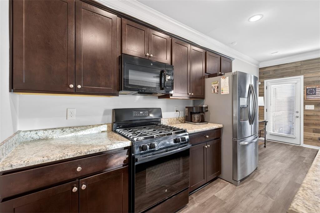 286 Turtle Creek Drive Winder, GA 30680 - Photo 8 of 39 a kitchen with granite countertop wooden cabinets and stainless steel appliances