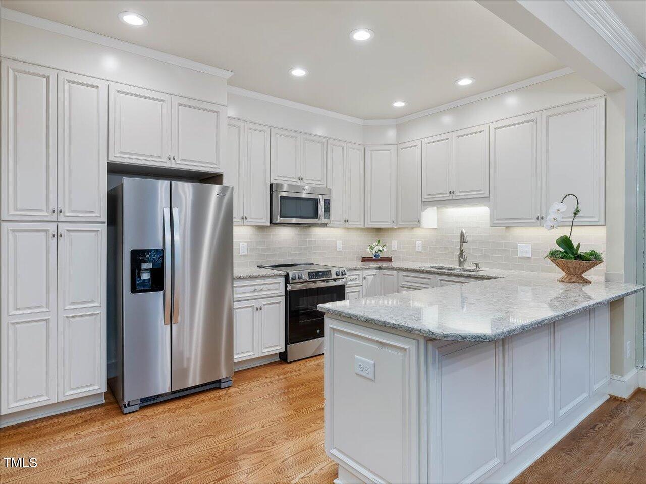 3347 Ridgecrest Court Raleigh, NC 27607 - Photo 10 of 65 a kitchen with kitchen island granite countertop a sink appliances and cabinets