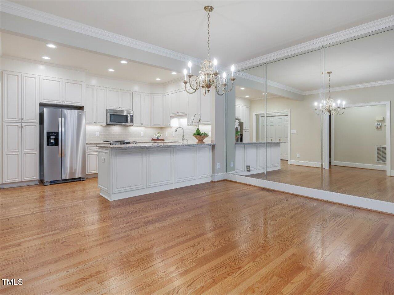 3347 Ridgecrest Court Raleigh, NC 27607 - Photo 14 of 65 a view of a kitchen with a refrigerator a ceiling fan and wooden floor