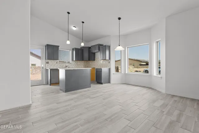 a view of a kitchen with kitchen island a counter top space stainless steel appliances and a chandelier
