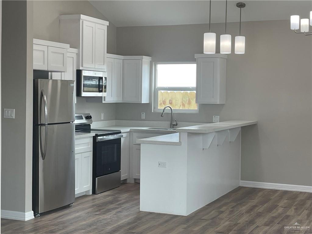 605 Sparrow Road Weslaco, TX 78596 - Photo 8 of 31 a kitchen with kitchen island white cabinets and stainless steel appliances