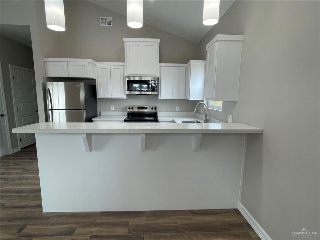 605 Sparrow Road Weslaco, TX 78596 - Photo 9 of 31 a kitchen with kitchen island granite countertop a sink cabinets and stainless steel appliances