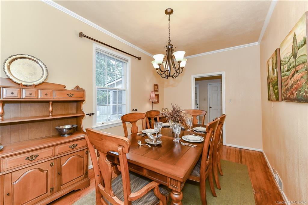 621 Westbury Road Charlotte, NC 28211 - Photo 17 of 45 a view of a dining room with furniture a chandelier and wooden floor