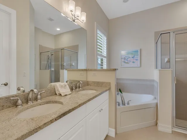 a bathroom with a granite countertop bathtub a sink and mirror