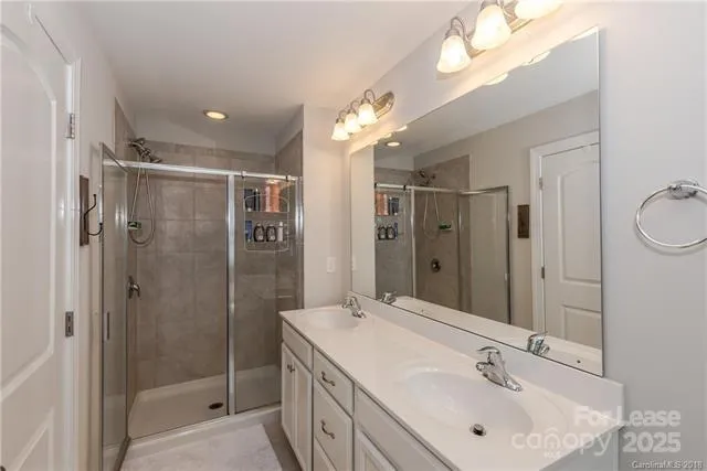 a bathroom with a sink shower and a mirror