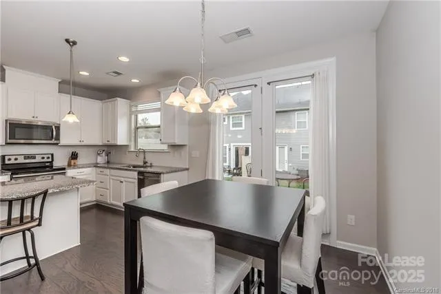 a large kitchen with stainless steel appliances a large center island attached withe living room