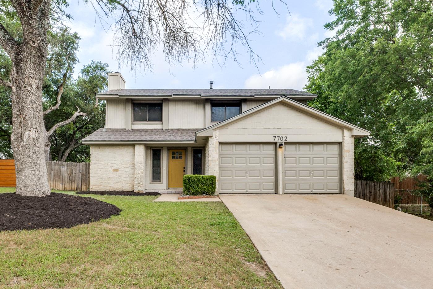 7702 Turquoise Trail Austin, TX 78749 - Photo 1 of 1 View of front facade with a garage, a chimney, concrete driveway, roof with shingles, and stone siding