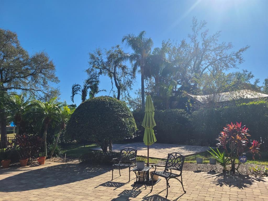 10628 Pontofino Circle Trinity, FL 34655 - Photo 39 of 75 a backyard of a house with table and chairs under an umbrella