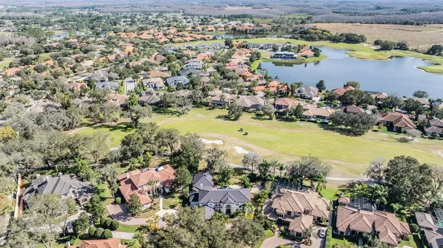 an aerial view of a house with yard and swimming pool