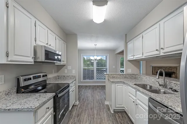 a kitchen with stainless steel appliances granite countertop a sink stove and cabinets
