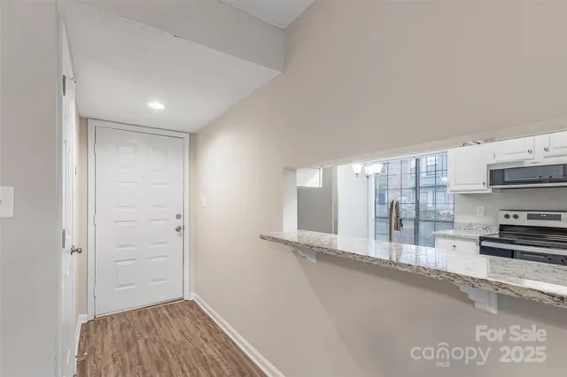a view of a kitchen with stainless steel appliances wooden floor and a window