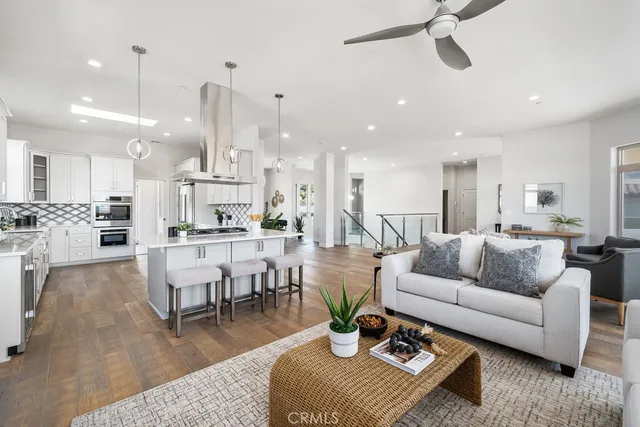 a kitchen with stainless steel appliances kitchen island granite countertop a table chairs and a refrigerator