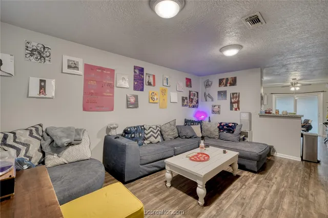 a living room with furniture a rug and white walls