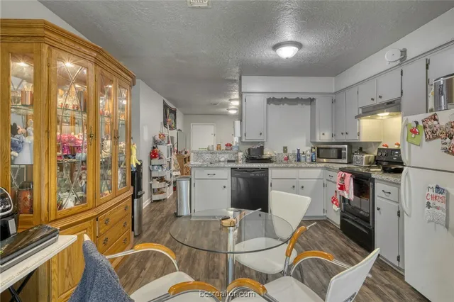 a kitchen with a refrigerator and a stove top oven