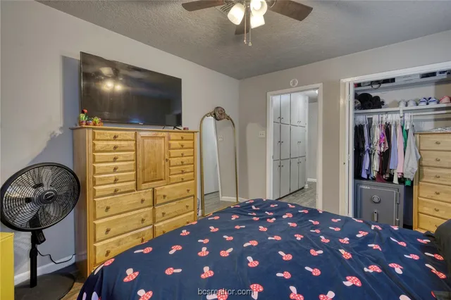 a bedroom with a bed and a flat tv screen on dresser