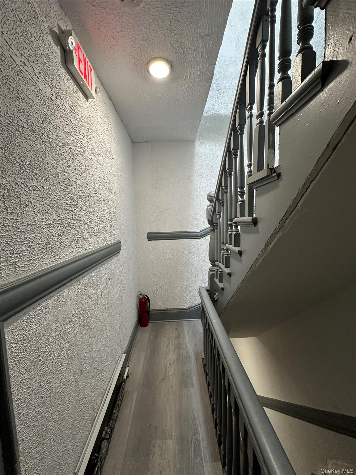 31 Victor Street Yonkers, NY 10701 - Photo 7 of 11 Staircase with a textured wall, wood finished floors, and a textured ceiling