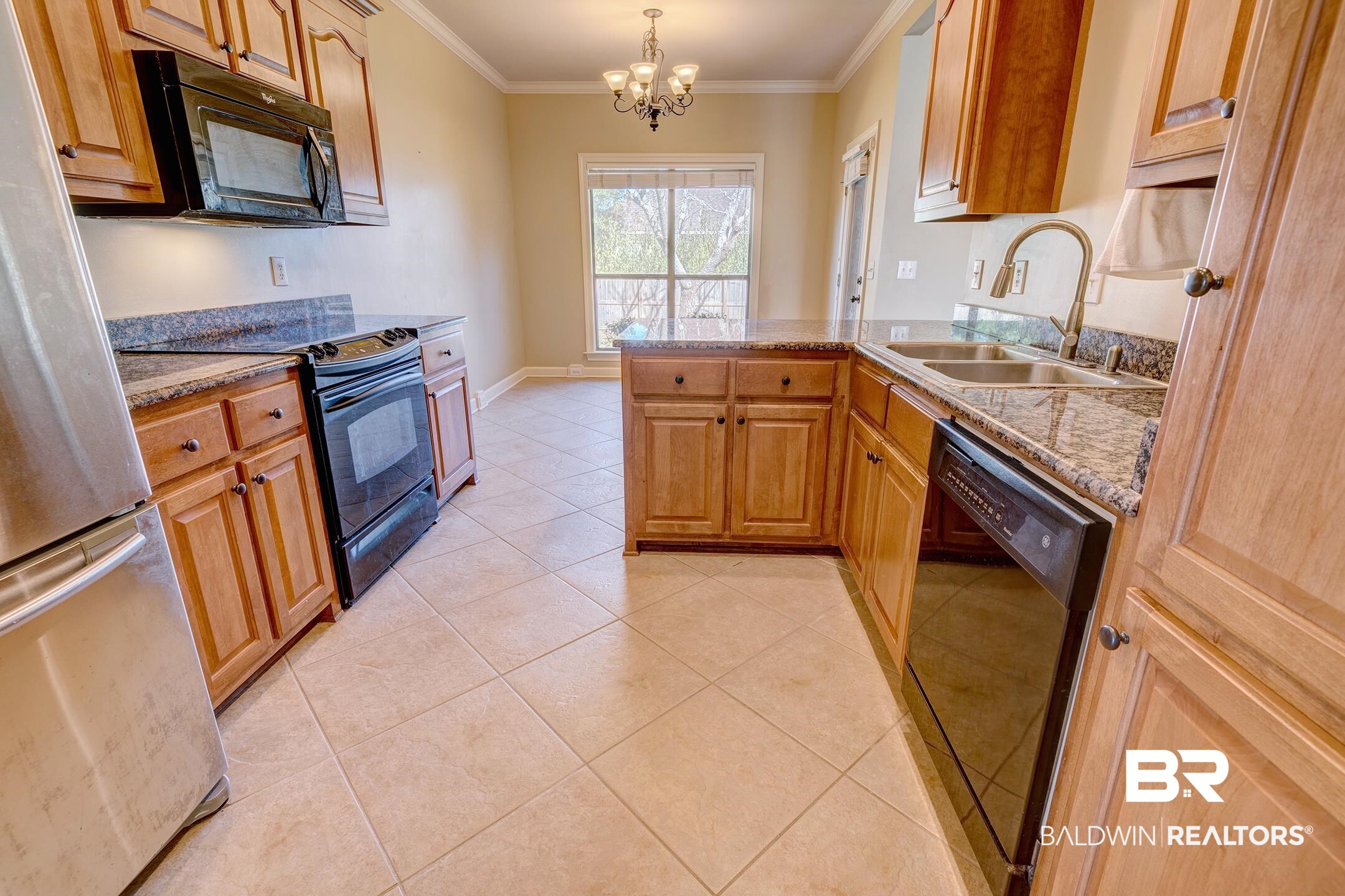 9421 Collier Loop Daphne, AL 36526 - Photo 12 of 31 Kitchen with a peninsula, black appliances, ornamental molding, a chandelier, and hanging light fixtures