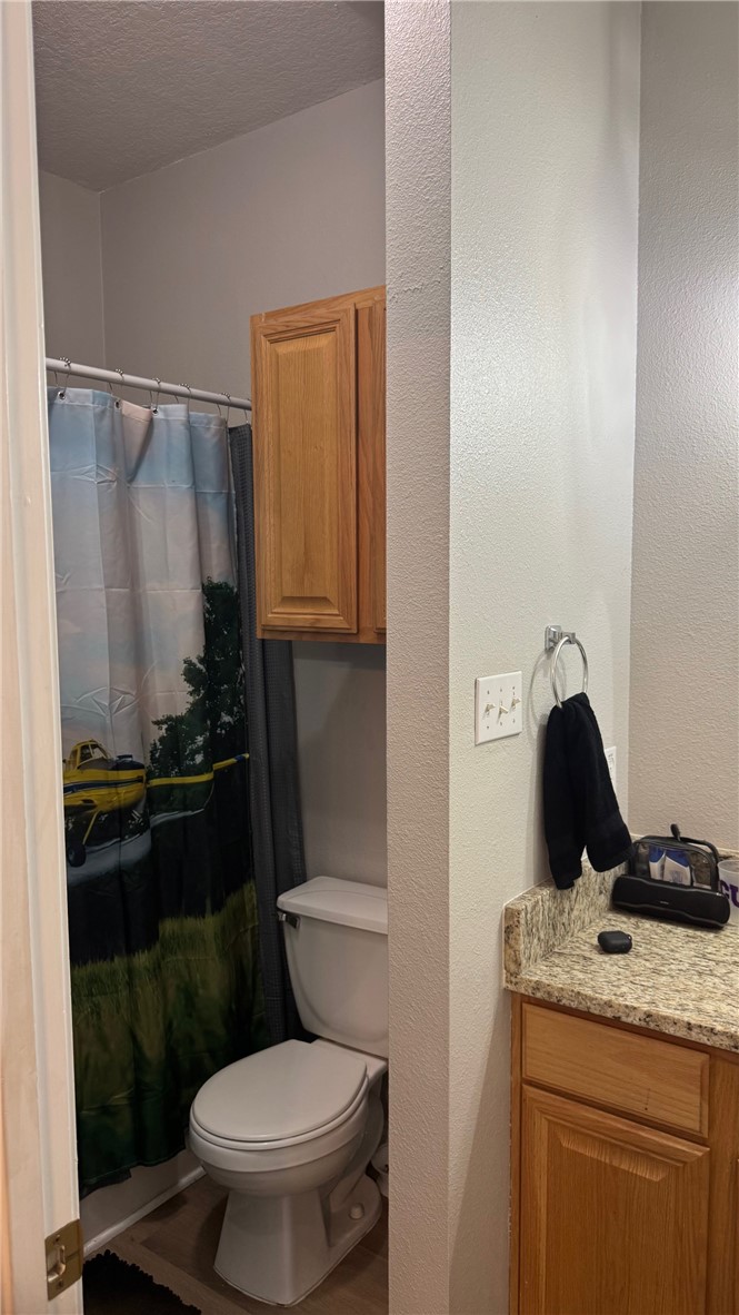 206 Fraternity Row College Station, TX 77845 - Photo 13 of 18 a bathroom with a granite countertop toilet sink and mirror