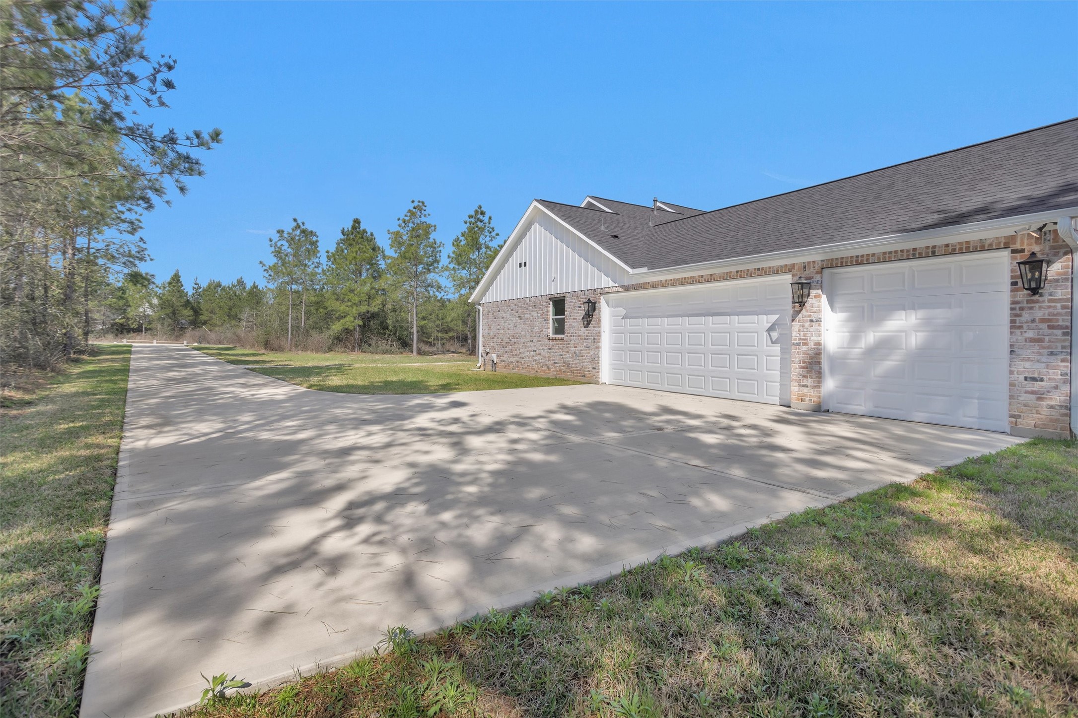 12744 Oak Barrel Road Willis, TX 77378 - Photo 42 of 50 An impressive, expansive driveway creates a grand approach to the home, offering both privacy and striking curb appeal. The long drive provides ample parking space for guests while enhancing the estate-style feel of the property.
At the end of the drive, a spacious three-car garage offers abundant room for vehicles, storage, or even a workshop setup.
