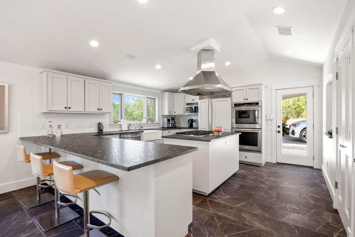 a large kitchen with kitchen island a large counter space and stainless steel appliances