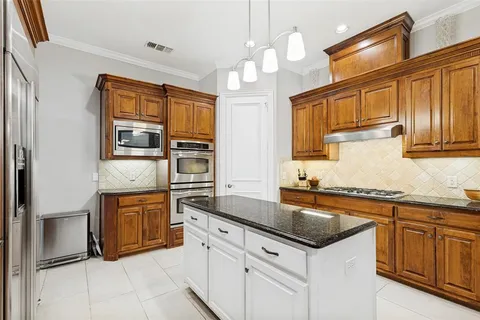 a kitchen with stainless steel appliances granite countertop a sink and dishwasher a stove with wooden cabinets