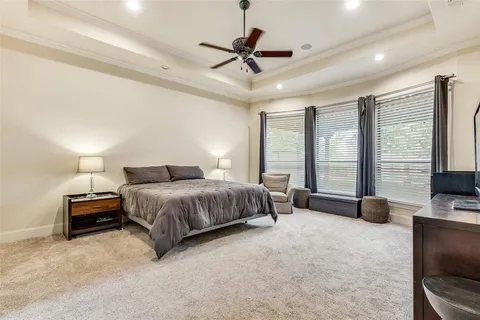a spacious bedroom with a bed a couch and a chandelier
